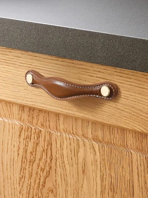Installed brown leather drawer pull on wood cabinet with zinc alloy base, part of Leather Drawer Pulls 5 Pack, 5 Inch 128mm Leather Handles.