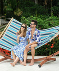 Couple relaxing on a Sunbrella Fabric Hammock With 13 Ft Wood Arc Stand For Two People Outdoor Patio Setup All Weather Fade Resistant