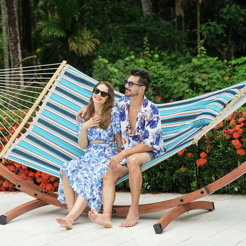 Couple relaxing on a Sunbrella Fabric Hammock With 13 Ft Wood Arc Stand For Two People Outdoor Patio Setup All Weather Fade Resistant