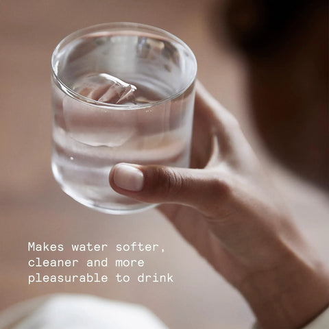 Hand holding glass of water filtered by Purifier Pitcher Filter Refill Granules That Cut Heavy Metals Lead And Copper Reducing Limescale