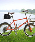 Orange bicycle with basket and bag beside lake, highlighting use of Self Sealing Bike Inner Tubes 20x1.75 to 2.125 AV32mm With Schrader Valve