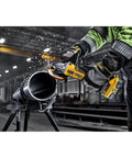 Badass 20V Max Xr Brushless Cordless Angle Grinder in use on steel pipe, showcasing sparks and precision cutting.