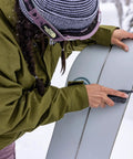 Using Suspension NXT 15 In 1 EDC Multitool on ski equipment, showing needlenose pliers and pocket knife in snowy setting