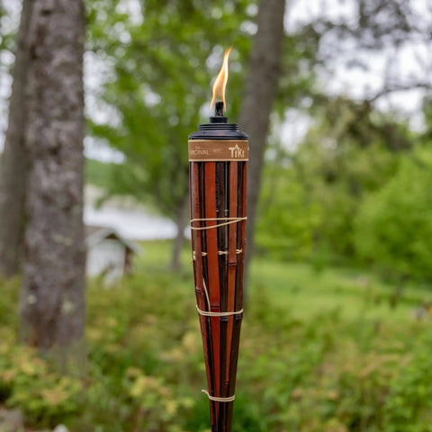 Close-up of 60 Inch Bamboo Torches 4-Pack With Easy Pour 12 Oz Canisters, Long-Lasting Fiberglass Wicks And Snuffers in walnut finish outdoors.