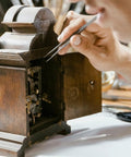 Person using tweezers to repair vintage clock with Stainless Steel Watch Band Pins And Spring Bars Replacement Kit 110pcs tool on table.