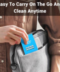 Blue lens cleaning tissue tag being inserted into a gray backpack pocket.