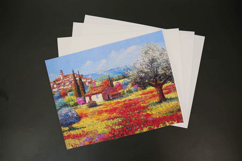 Colorful village landscape printed on 100 Percent Printable Cotton Canvas Sheets For Inkjet Printers, Matte White 8.5 By 11 Inches, 17 Mil Thick, Pack Of 10, Totally Real Fabric Printing With High Resolution Ink, Tear Resistant DIY Craft Canvas For Inkjet Projects, shown on black background.
