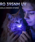 Ultra Thin Rechargeable Flashlight 700 Lumen Slim Magnetic Work Light with COB Side Light UV illuminating a cat in dark.