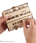 Knight Bus 3D Puzzle With 268 Pieces And 7.7 Inch Build Size Transformable Triple Decker Design, Spring Powered Motor, Flip Gear Coasting, Pre Laser Cut Wood Panels And No Glue Needed For Quick Hands On Fun. Hands assembling wooden 3D bus model