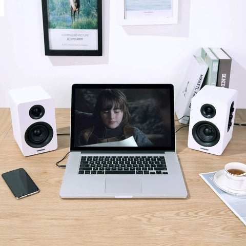 SW208 3 Inch Active Bluetooth 5.0 Bookshelf Speakers Pair With 60 Watt Output Carbon Fiber Drivers Built In 24 Bit DAC Dynamic 3D Surround Sound Crisp Highs And Punchy Bass For Gaming And Monitor Setup White Finish next to laptop on desk