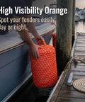 Solid Nylon Boat Fenders for Docking and Marine Anti Collision Protection in high visibility orange, being placed on a dock.