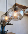 Bottom Line Quality Clear Marble Glass Pendant Lights 2 Pack Hand Blown Globe Hanging Lamp in kitchen setting with warm glow.