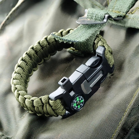 5 In 1 Paracord Survival Bracelet with Compass Fire Starter Whistle Glass Breaker and Paracord on green backpack