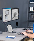 Zero Hassle Dual Monitor Mount For 17 To 32 Inch Screens with the user working at a desk with two monitors.