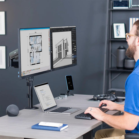 Zero Hassle Dual Monitor Mount For 17 To 32 Inch Screens with the user working at a desk with two monitors.