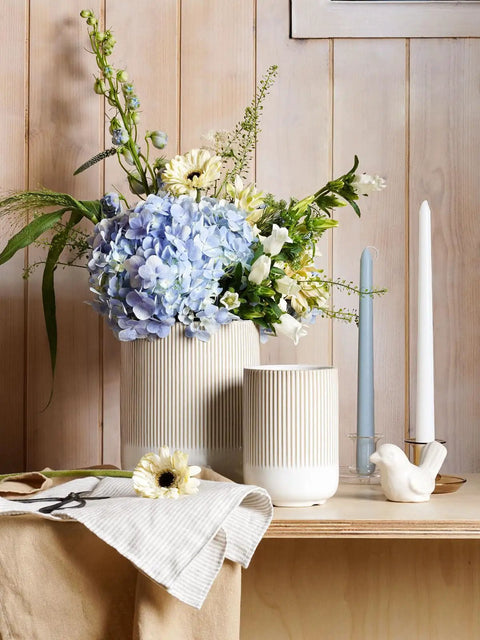Two Piece Ceramic Utensil Holder Set For Kitchen Counter With Fluted Warm White Glaze Large 7.3 Inch And Small 5.4 Inch Crocks For Spatulas Spoons Whisks And More Perfect Countertop Organizer on a wooden surface with flowers