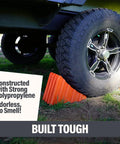 Beefy Wheel Chocks 2 Pack Non Slip Solid Polypropylene Prevent Rolling On Slopes For RVs Trailers Campers Trucks And Boats Durable Weatherproof Stabilizers That Are Easy To Use, securing a vehicle tire with bright orange non-slip surface.