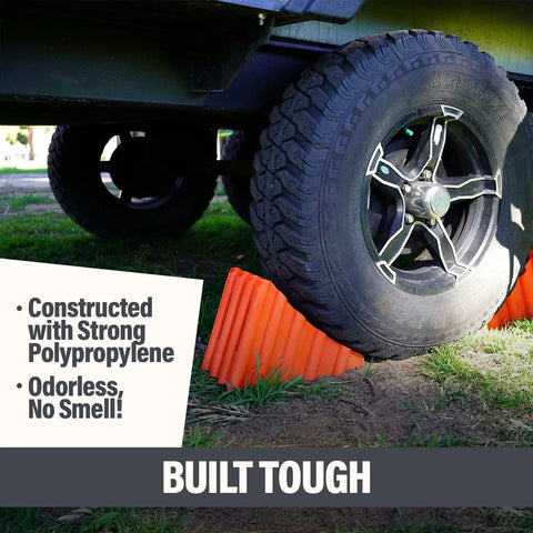 Beefy Wheel Chocks 2 Pack Non Slip Solid Polypropylene Prevent Rolling On Slopes For RVs Trailers Campers Trucks And Boats Durable Weatherproof Stabilizers That Are Easy To Use, securing a vehicle tire with bright orange non-slip surface.