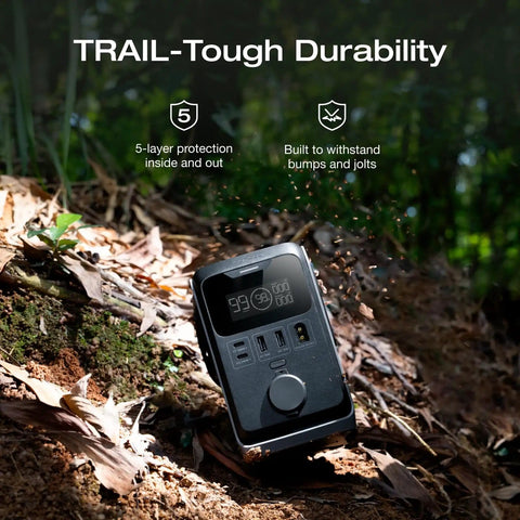 Trail 300 DC Power Bank Station 288Wh Portable Solar Generator resting on forest floor showing rugged durability and ports.