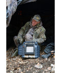 Hunting Buddy Space Heater 6K To 12K BTU Outdoor Heater in camouflage finish being used in a forest setting