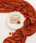 Rustic Fall Thanksgiving Table Runner Terracotta Cheesecloth Weave 120 Inches Long Hand Dyed Soft Cotton Gauze with a plate and decorations.