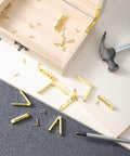 Gold Zinc Alloy Jewelry Box Hinges Set, 10 Pcs 90 Degree Small Hinges With 40 Screws on table next to wooden box and hammer