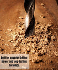12-inch brad-point drill bit drilling into wood with wood shavings.