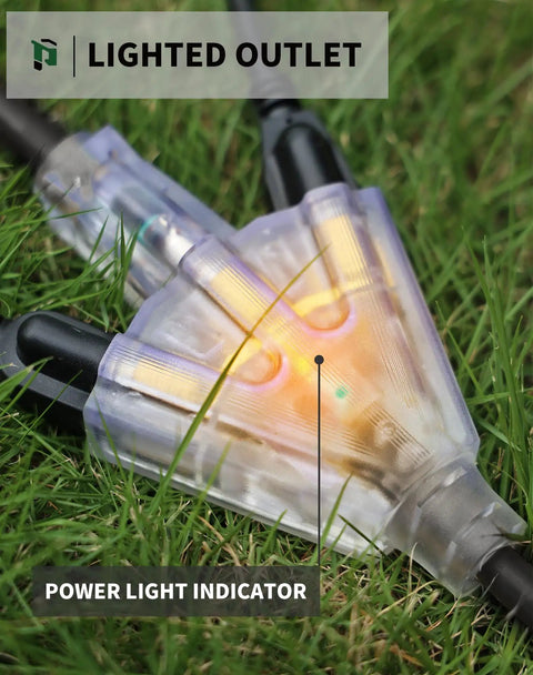 Close-up of the lighted end of a 25ft Heavy Duty Outdoor Extension Cord With 3 Outlets, 12 Gauge 3 Prong Waterproof Cable in grass.