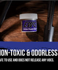 Extreme Weapons Grease EWG For Firearms shown in a 4 oz jar beside firearm parts on a wooden surface