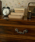 Drawer with Six Pack Antique Brass Drop Bail Pulls with Vintage Floral Base Plates for cabinets or dressers, 3-inch hole centers.