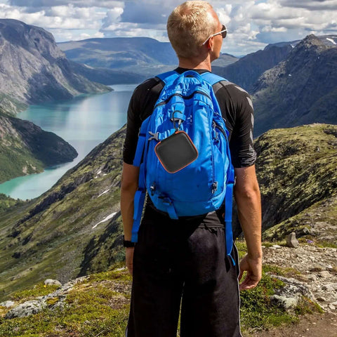 Man hiking with a bright orange Heavy Duty Bad Boy Hard Case For Garmin Xero C1 Pro And Xero C2 Chronograph attached to backpack.