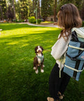 Person in park with backpack carrying Lightweight Outdoor Chair For Stadium Seats Camping Hiking And More Water Resistant Adjustable Straps