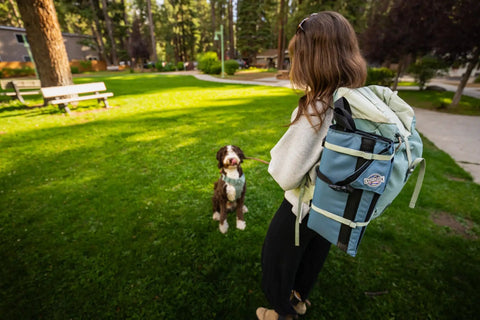 Person in park with backpack carrying Lightweight Outdoor Chair For Stadium Seats Camping Hiking And More Water Resistant Adjustable Straps