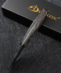 DC53 Steel Fixed Blade Knife With Rugged Shredded Carbon Fiber Handle, top view, against black scratch-patterned surface.