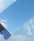 Window cleaning with a telescoping extension pole and blue sponge, sky reflection. Ideal for hard-to-reach exterior glass surfaces.