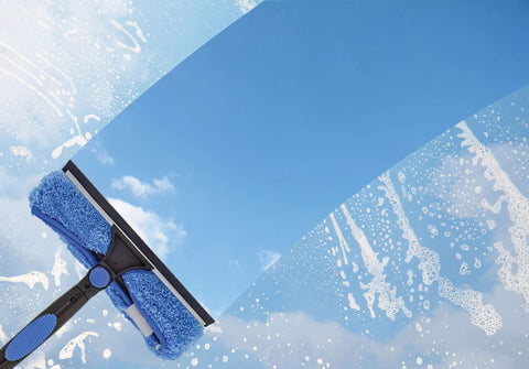 Window cleaning with a telescoping extension pole and blue sponge, sky reflection. Ideal for hard-to-reach exterior glass surfaces.