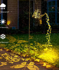 Upgraded Solar Watering Can With Lights Outdoor Hanging Lantern casting floral patterns on garden path at nighttime.
