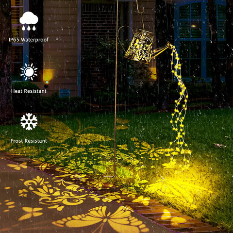 Upgraded Solar Watering Can With Lights Outdoor Hanging Lantern casting floral patterns on garden path at nighttime.