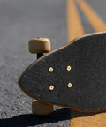 Skateboard with underside view showing One Eighth Inch Rubber Skateboard Riser Pads With Mounting Screws And Nuts, Durable Black.