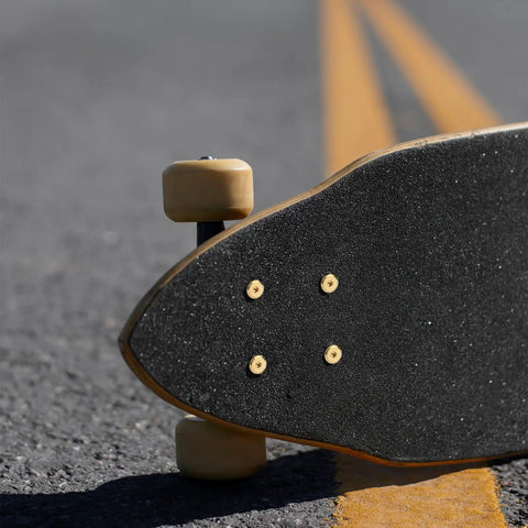 Skateboard with underside view showing One Eighth Inch Rubber Skateboard Riser Pads With Mounting Screws And Nuts, Durable Black.
