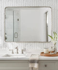 Bathroom scene with Peel And Stick Herringbone Kitchen Backsplash Tiles Self Adhesive Aluminum Composite PVC Marble White With Light Grey Veining For Easy DIY Install And Modern Look 7.7 Sq Ft Coverage Includes Bonus Gloves behind mirror.