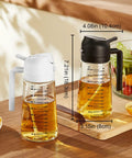 Game Changing Glass Olive Oil Sprayer For Cooking, 16 Oz Dual Pump Dispenser Bottle next to a salad and lemon on a wooden table.