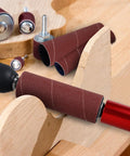 Installed spindle sander drum adapter on drill with burgundy rubber sanding sleeves, shaping curved wood edge.