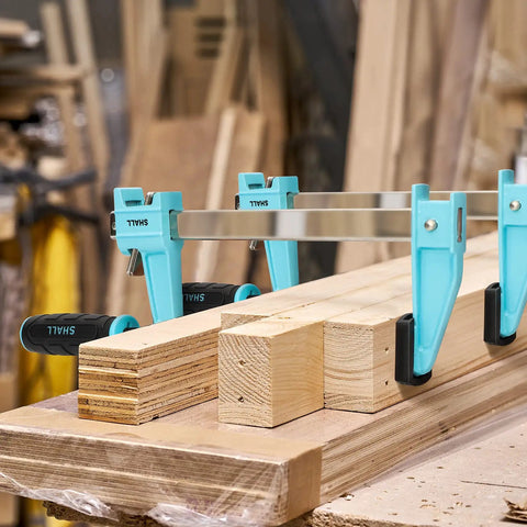 Beefy 6 Inch Steel Bar Clamps Set Four Pack Quick Release F Clamps clamping wooden planks on a workbench