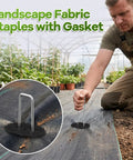 Gardener installing Heavy Duty 6 Inch Galvanized Landscape Staples Set With Gasket, 200 Pack Ground Pins on fabric in garden