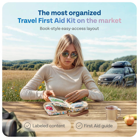 Front view of KeepGoing travel first aid kit opened on a wooden outdoor table, patterned case showing contents.