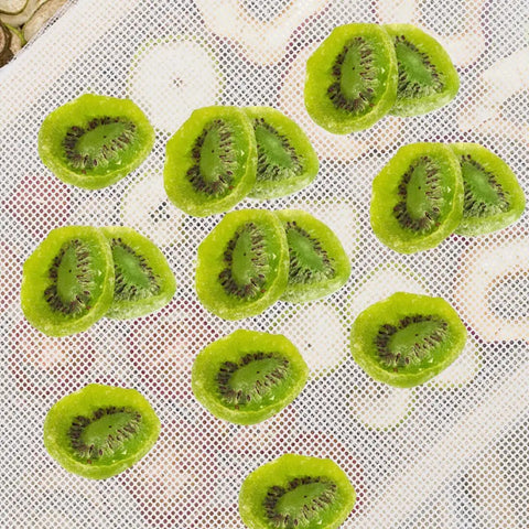 Kiwi slices on a Nonstick Silicone Dehydrator Mats 8 Pack Reusable Tray Liners For Food And Fruit Drying Steaming Mesh Sheets