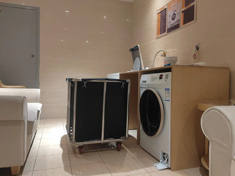 Heavy Duty 400L Rolling Laundry Cart with Steel Frame and Oxford Cloth beside a washing machine in a laundry room