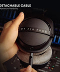 Hands holding DT 770 Pro X Wired Studio Headphones 48 Ohm Closed Back For Recording And Mixing, showing detachable cable feature.