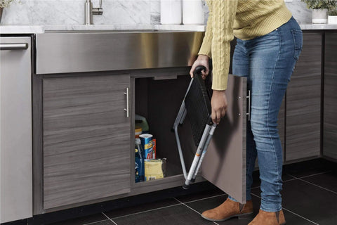 Person storing One Step Steel And Resin Go-To Step Stool Without Handle In Platinum And Black, Lightweight Yet Sturdy and Compact